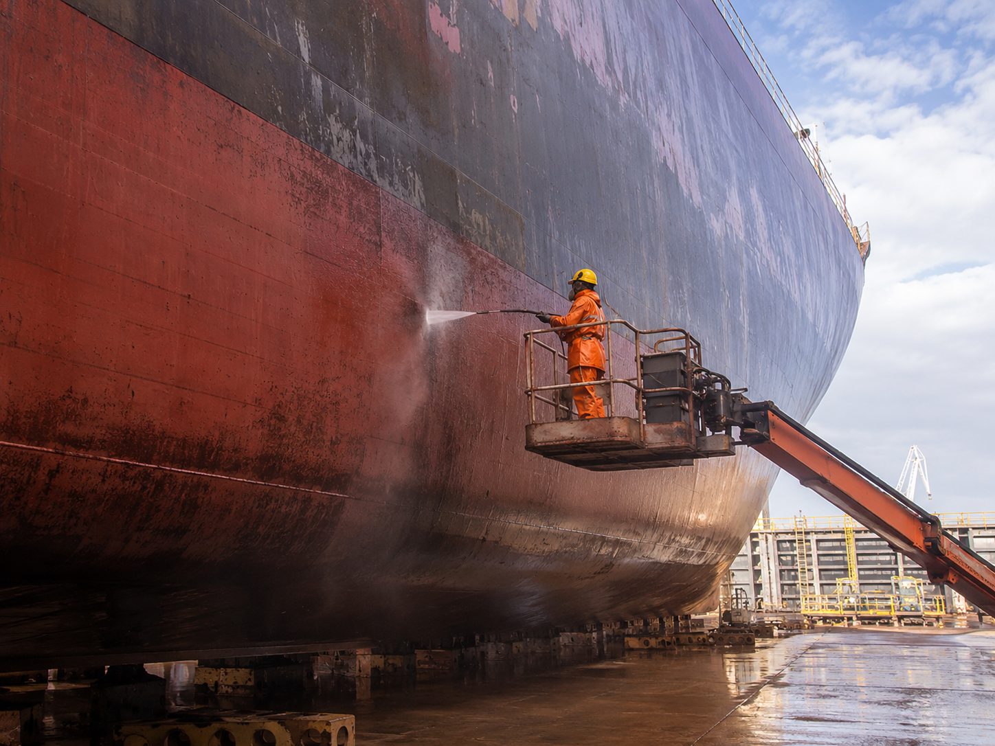 UHP-Waterblasting an einem Schiffsrumpf im Trockendock